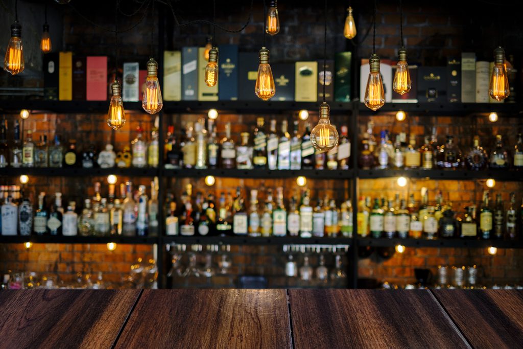 Wooden table with soft liquor bar background